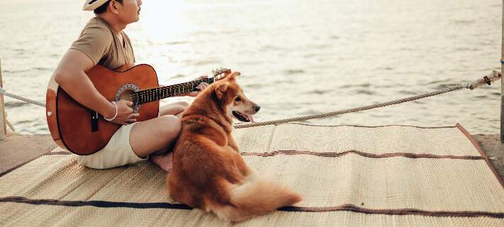 Man playing guitar with dog