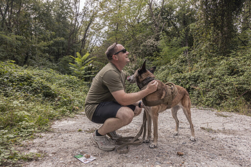 A man and a dog in a forest.