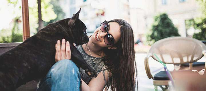 Girl and her french bulldog at a pet friendly restaurant. 